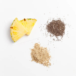 2 slices of pineapple and on the right side is some chia seeds and below is a light brown powder on a white surface.